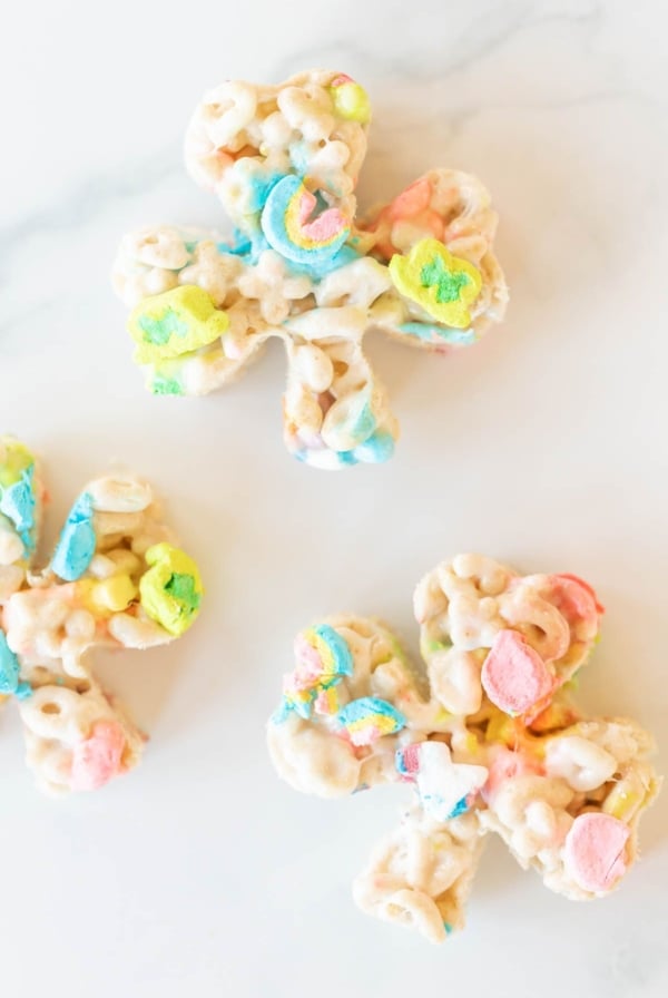 Lucky charm bars cut into clovers and placed on a marble countertop.