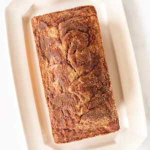 a loaf of banana bread on a white platter