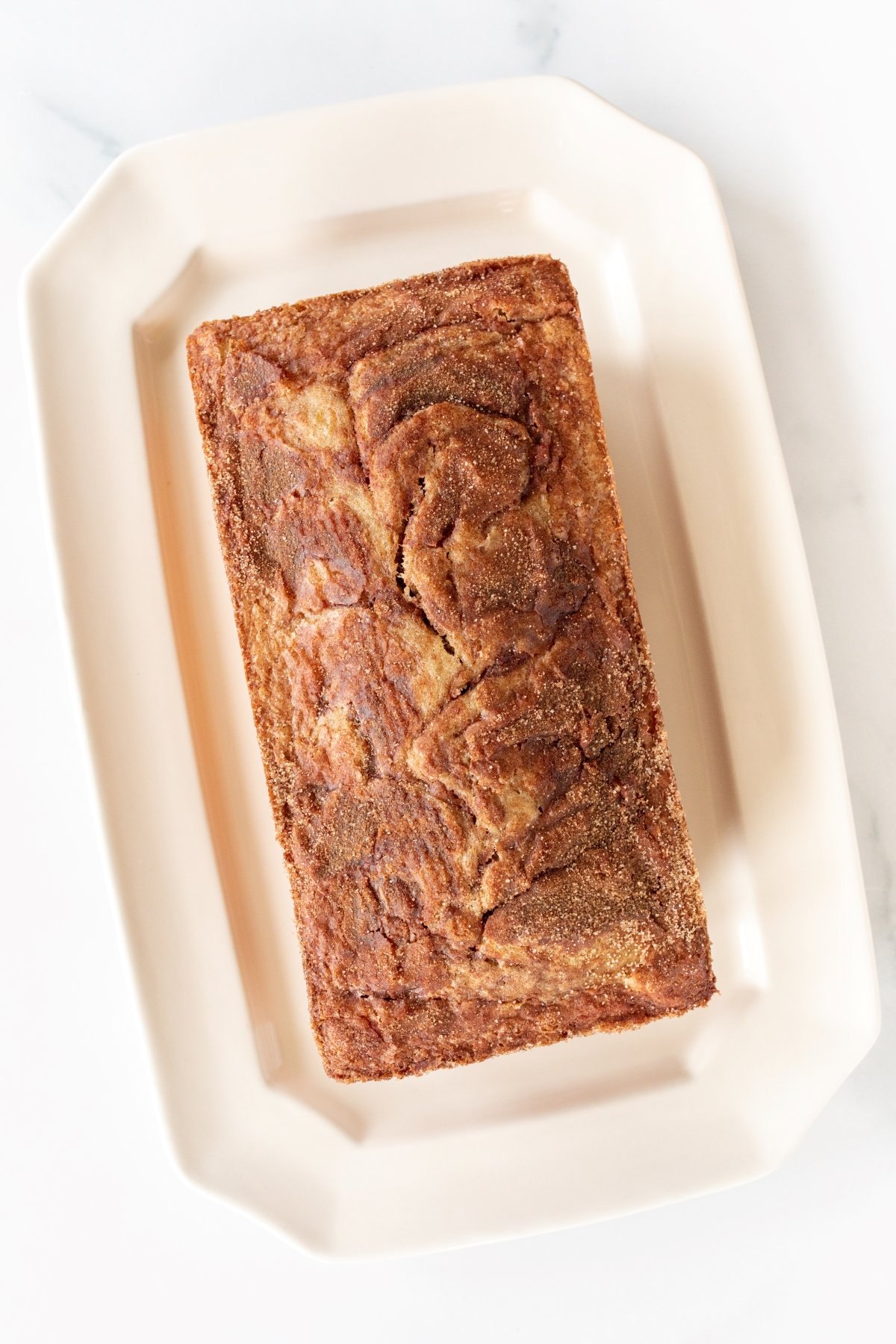 a loaf of banana bread on a white platter