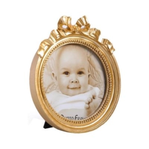 A gold picture frame with a baby's photo in it displayed in a tween girl bedroom.