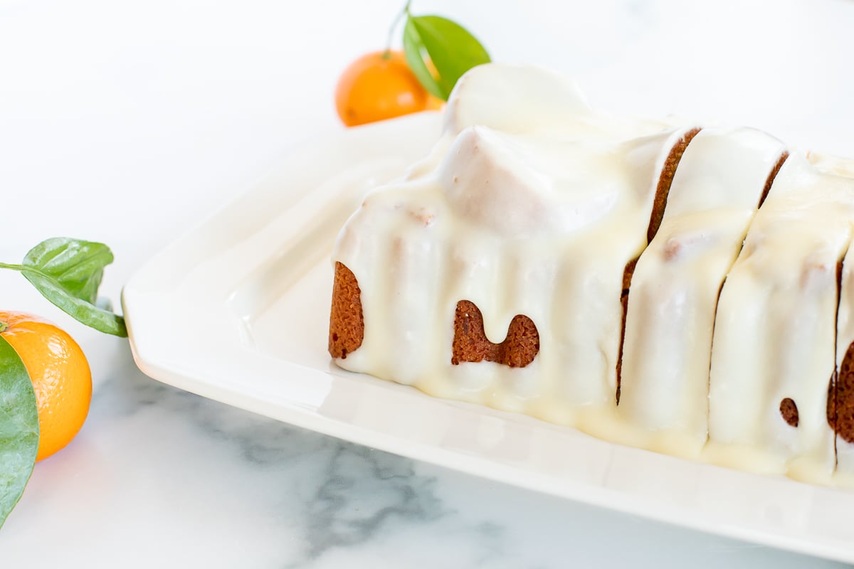 An orange pound cake on a white serving platter.