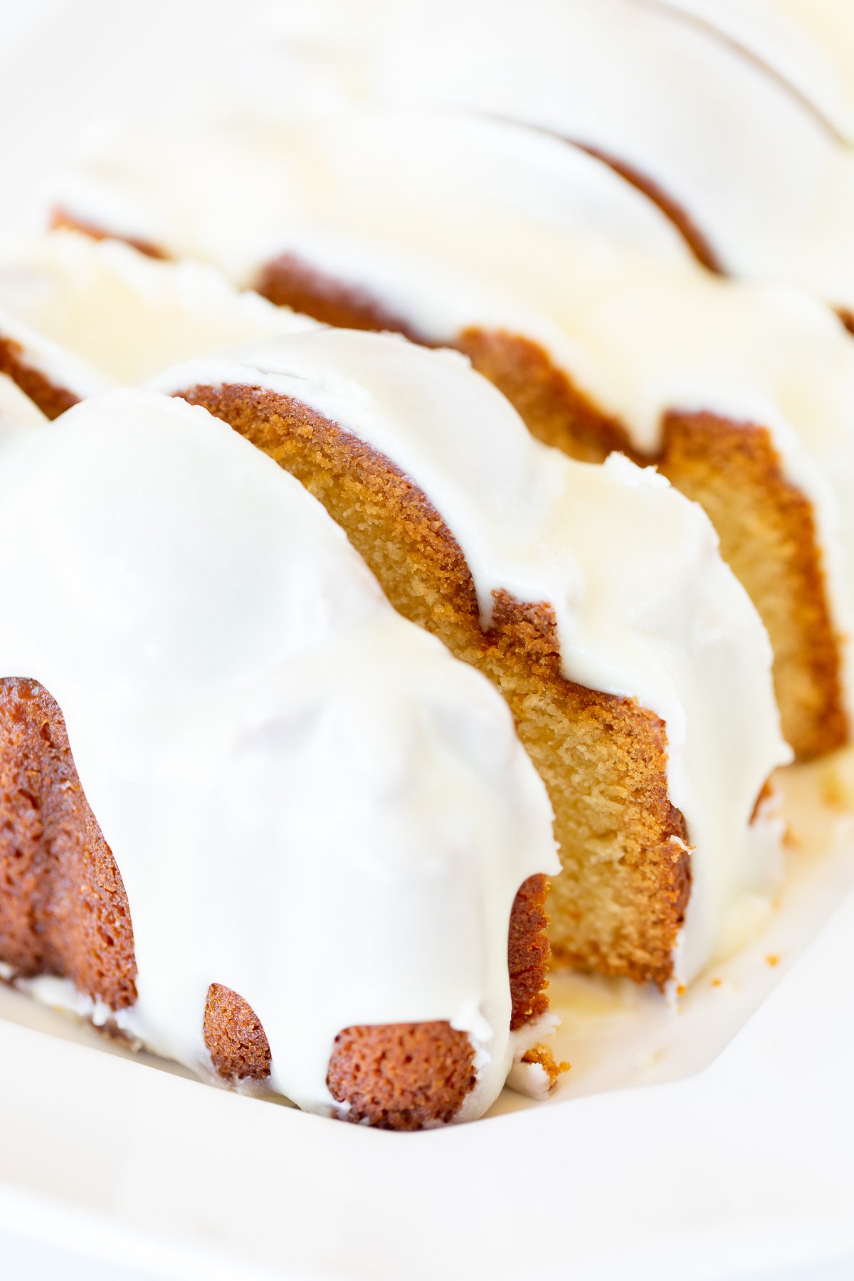 An orange pound cake on a white serving platter.