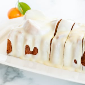 An orange pound cake on a white serving platter.