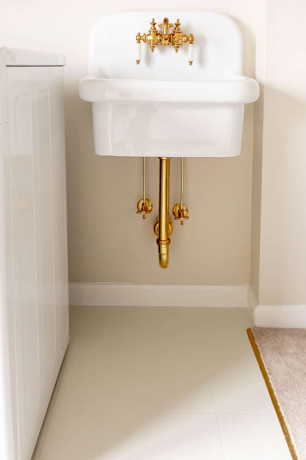 Update a home like this image: painted linoleum in a laundry room with a vintage inspired white wall sink above.