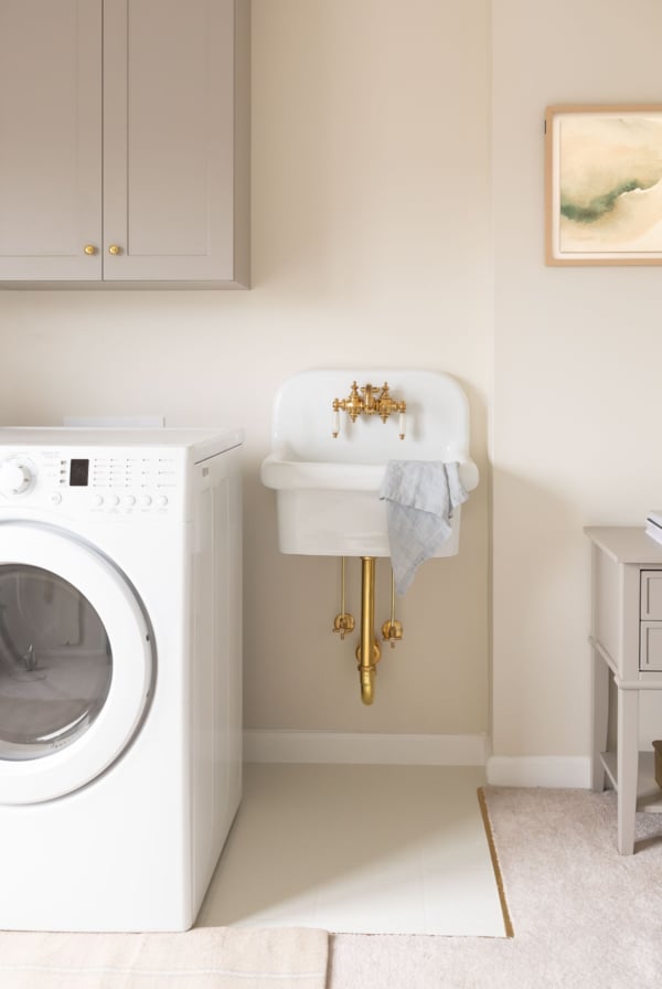 A laundry room with a washer and dryer and painted vinyl floors.