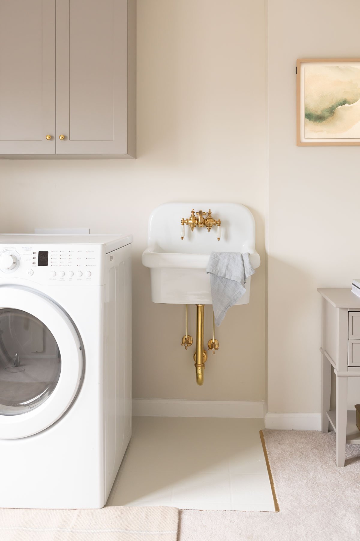 A laundry room with a washer and dryer and painted vinyl floors.