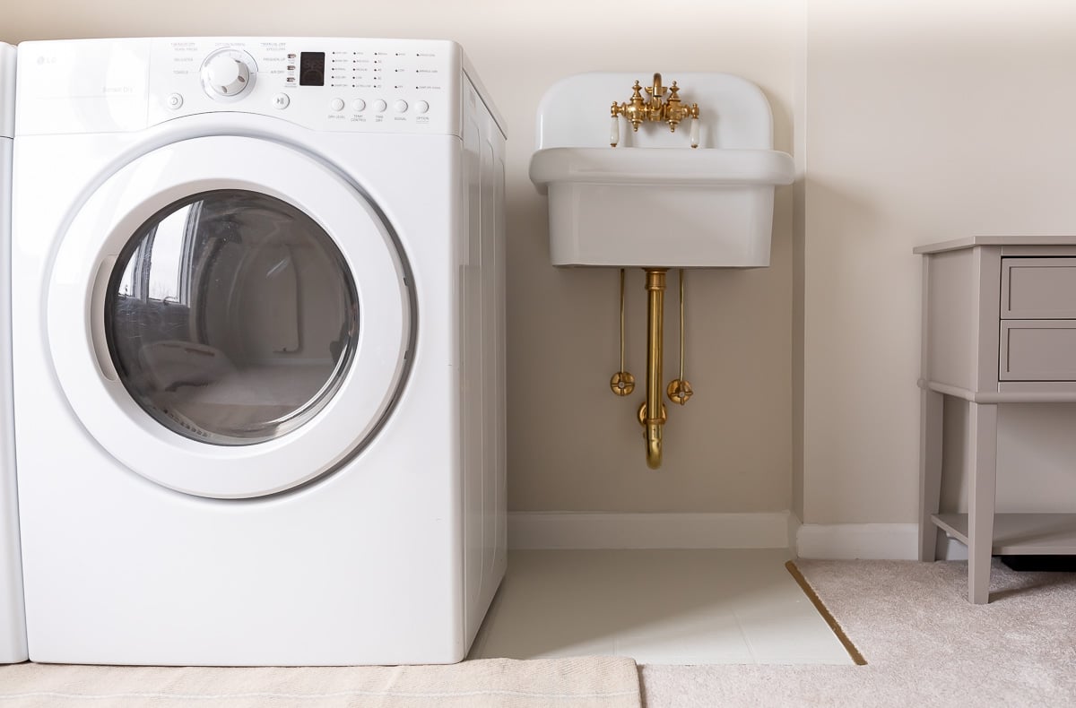 A laundry room with a washer and dryer and painted vinyl floors.