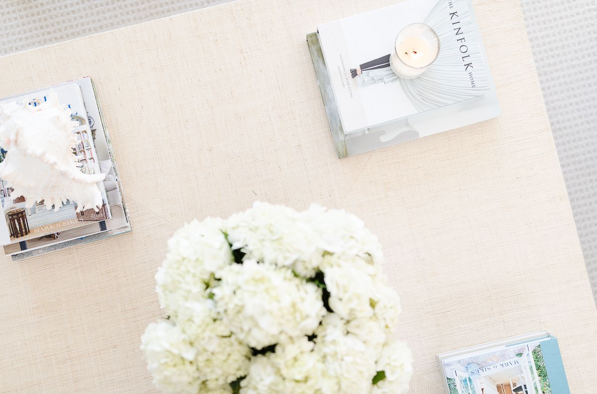 White flowers and coffee table books on a modern coastal coffee table