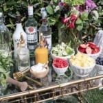 A mojito bar set up outdoors on a gold bar cart