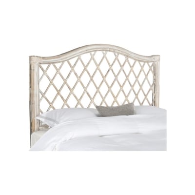 A white rattan bed with a white headboard.