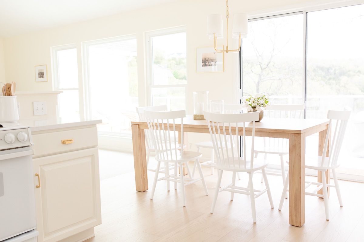 A white kitchen dining area with wide white oak floors.