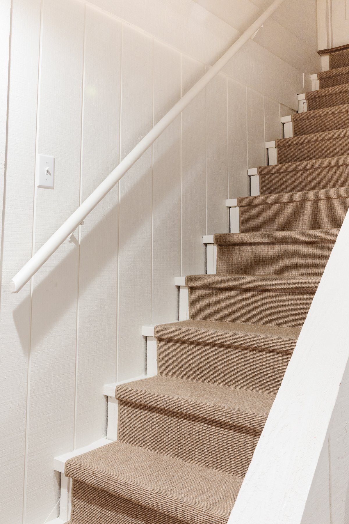 A stairwell painted in Benjamin Moore Swiss Coffee.