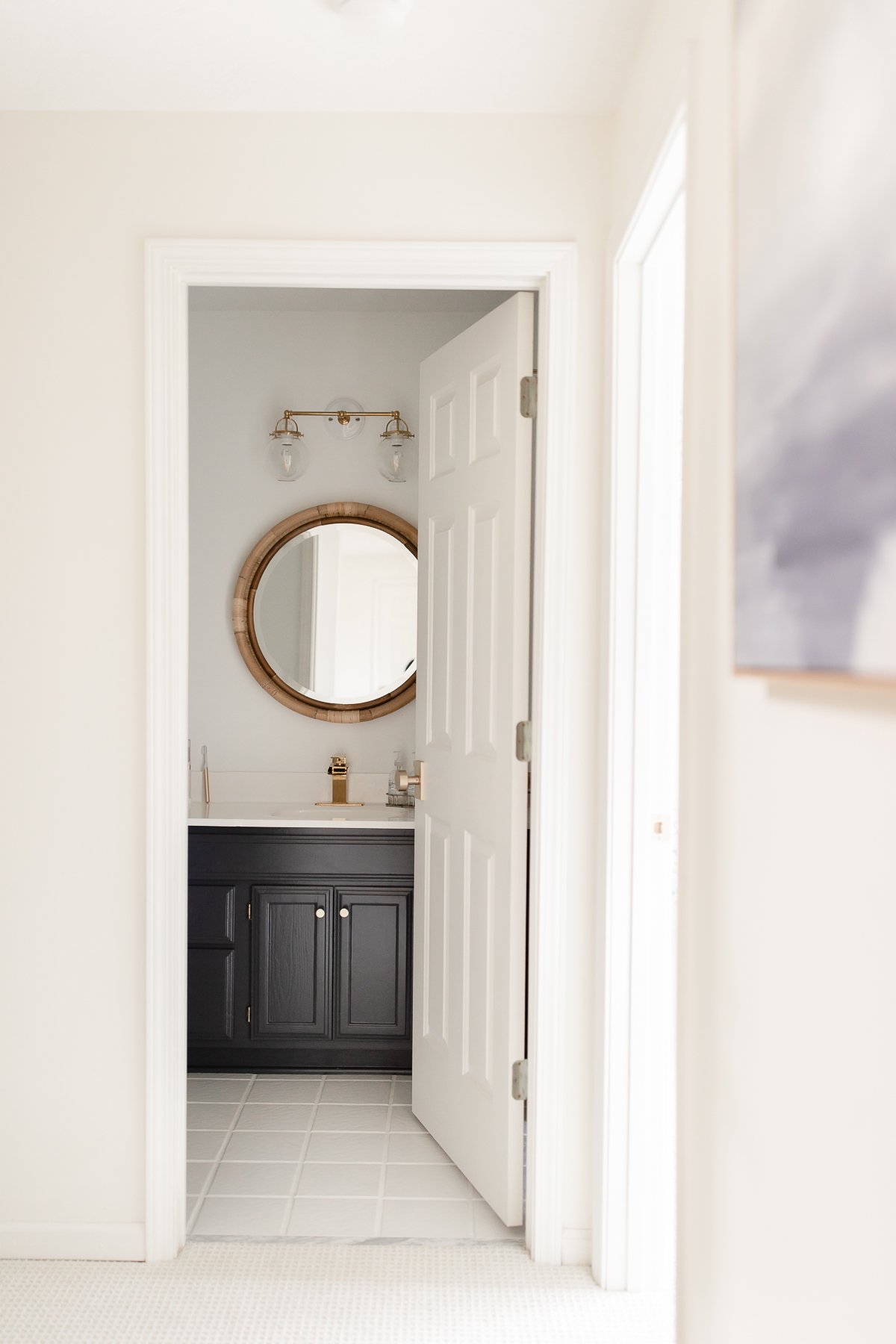 A white bathroom with a vanity painted in Benjamin Moore Hale Navy.