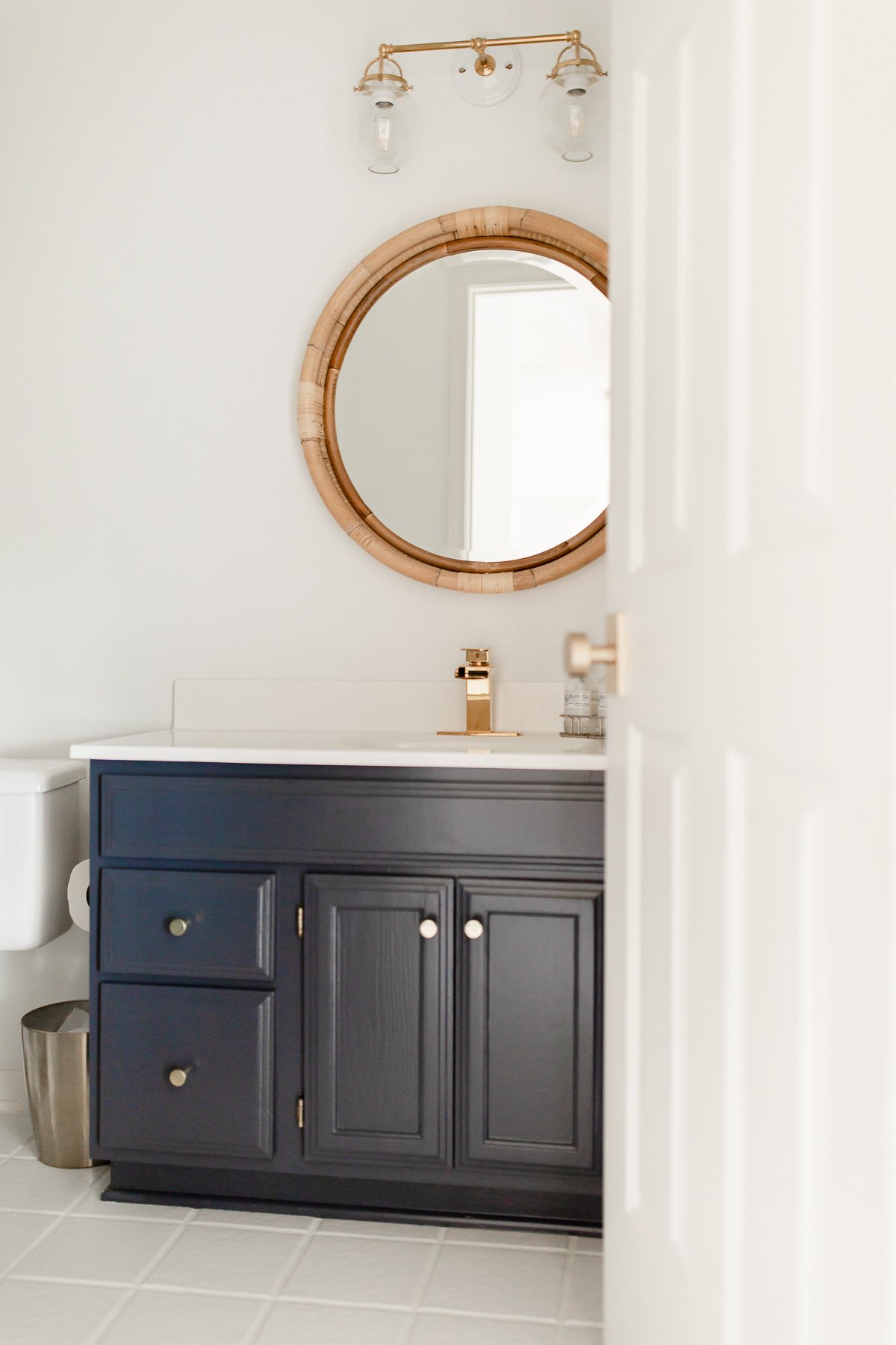 A white bathroom with a vanity painted in Benjamin Moore Hale Navy.