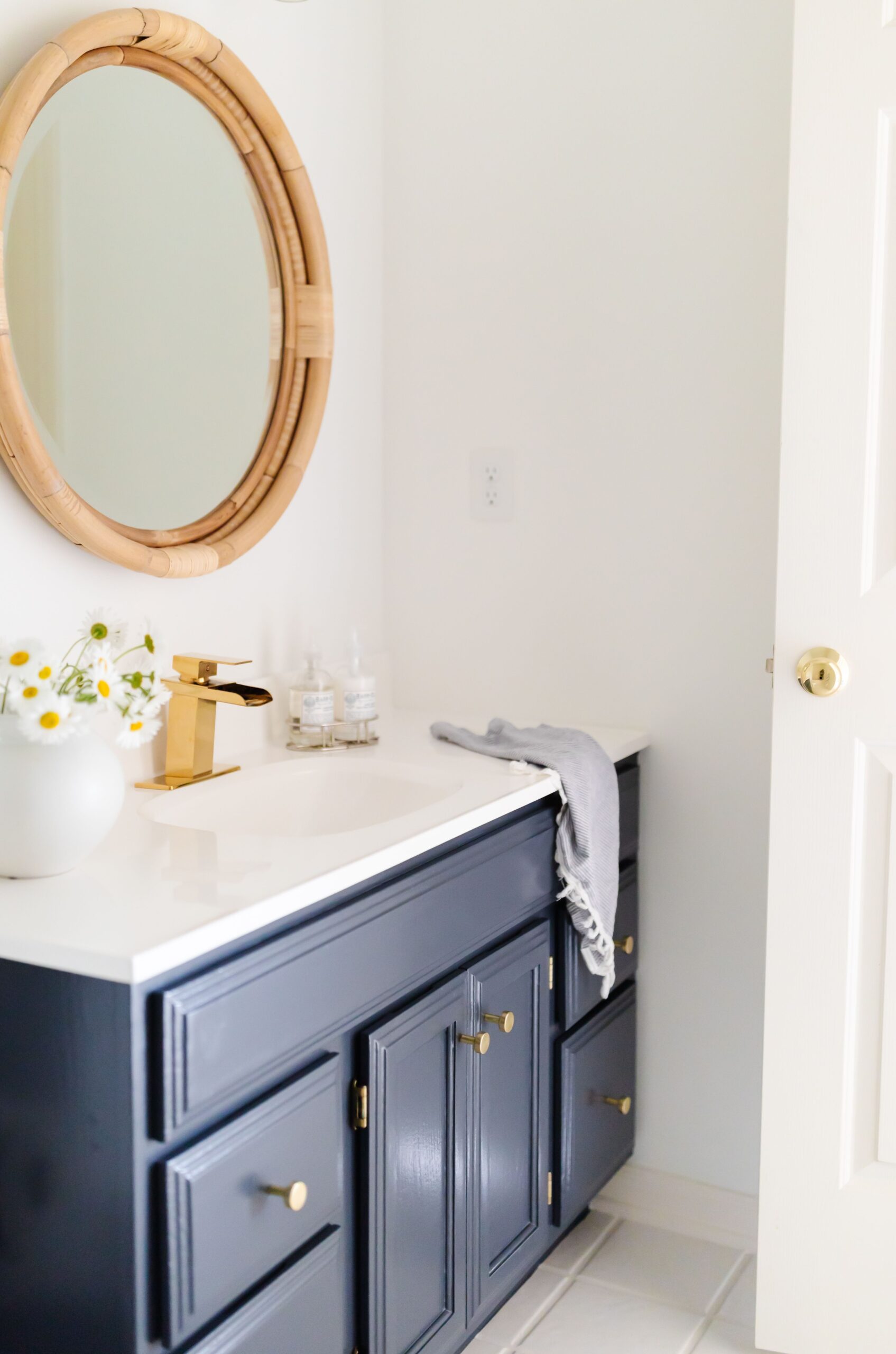 A white bathroom with a vanity painted in Benjamin Moore Hale Navy.