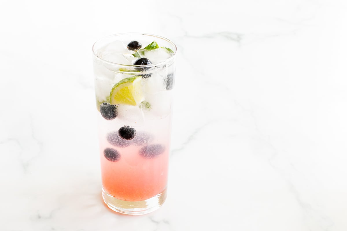 blueberries and lime in a clear glass