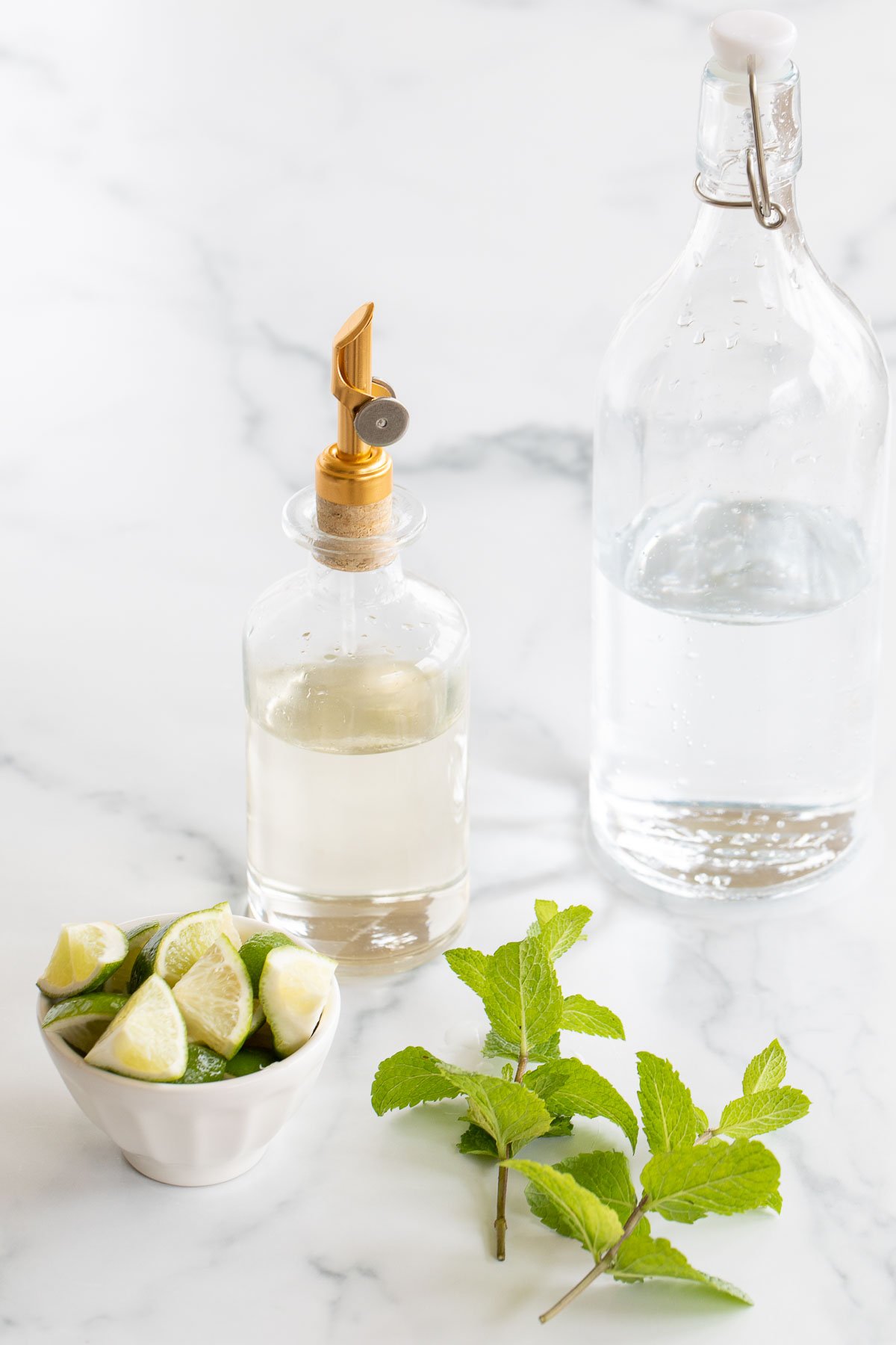 Ingredients for a virgin mojito mocktail on a white countertop.