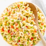A white bowl full of macaroni salad.