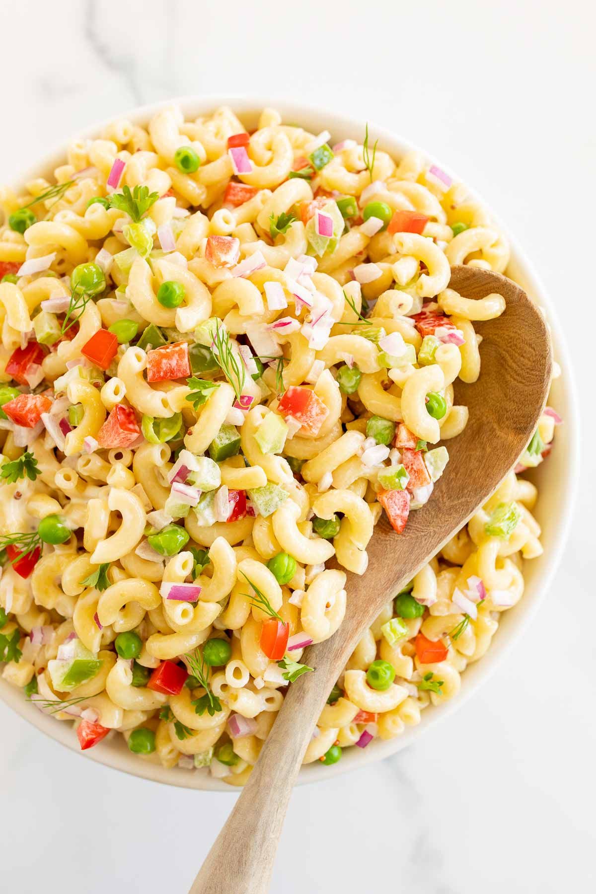 A white bowl full of macaroni salad.