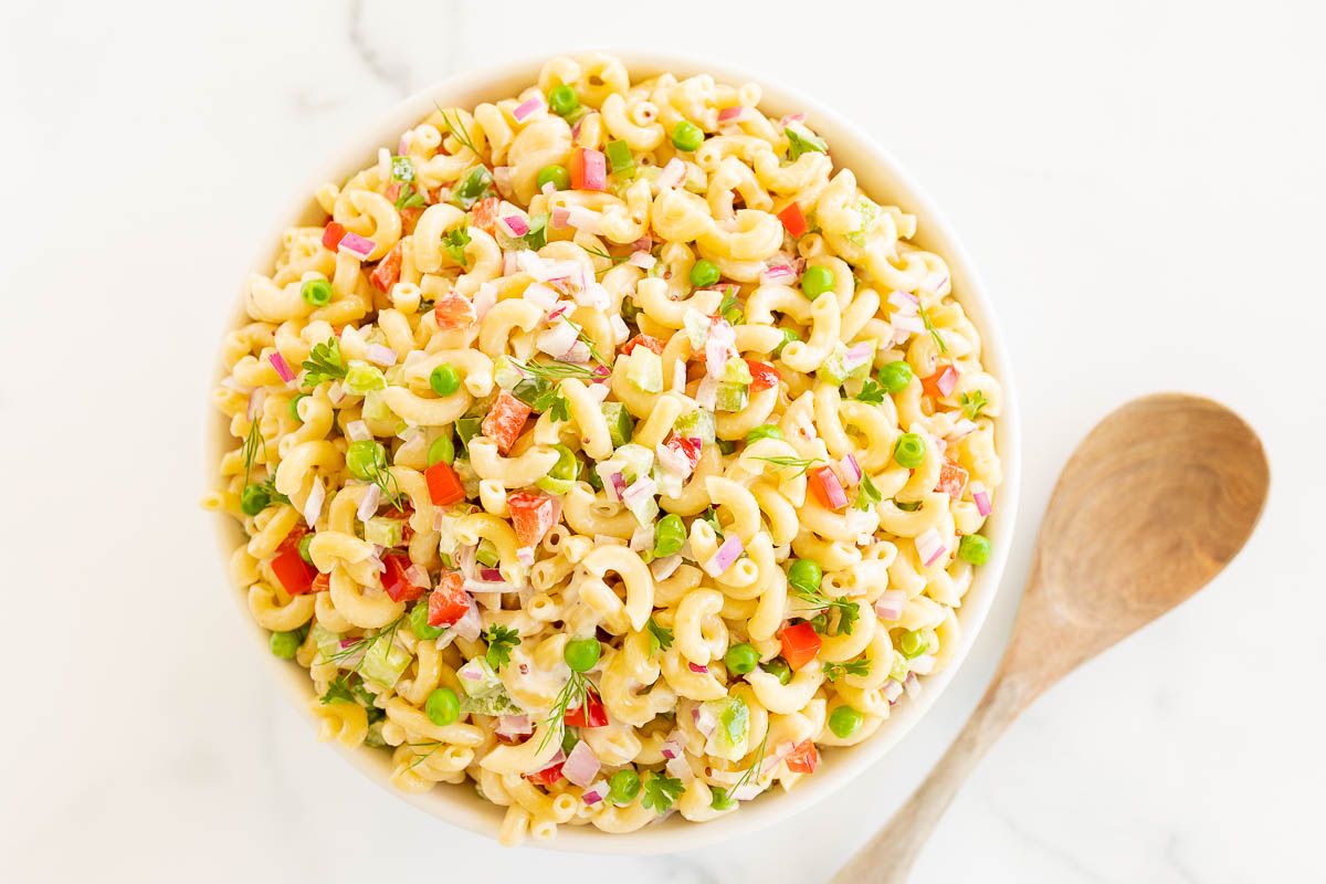 A white bowl full of macaroni salad.