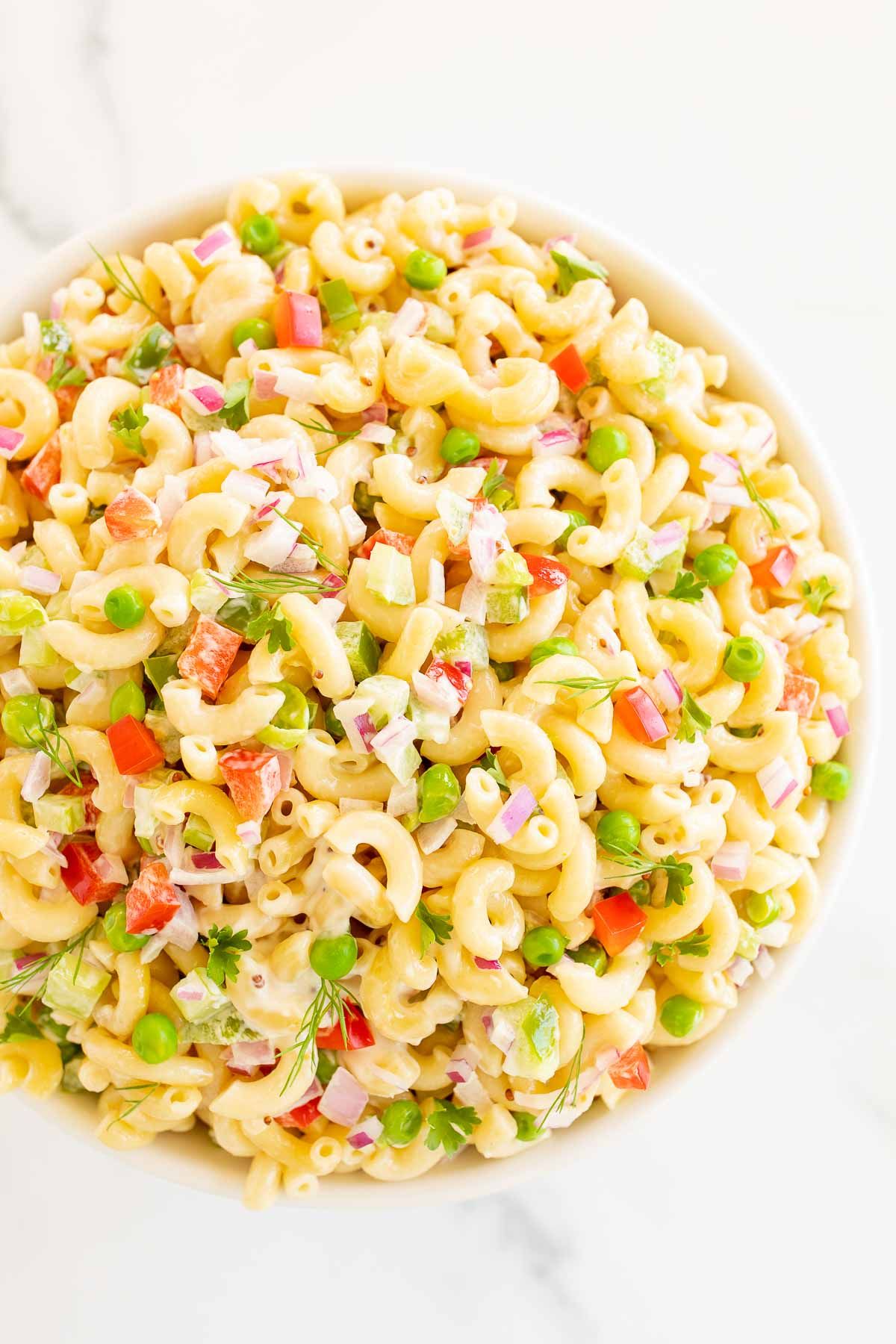 A white bowl full of macaroni salad.