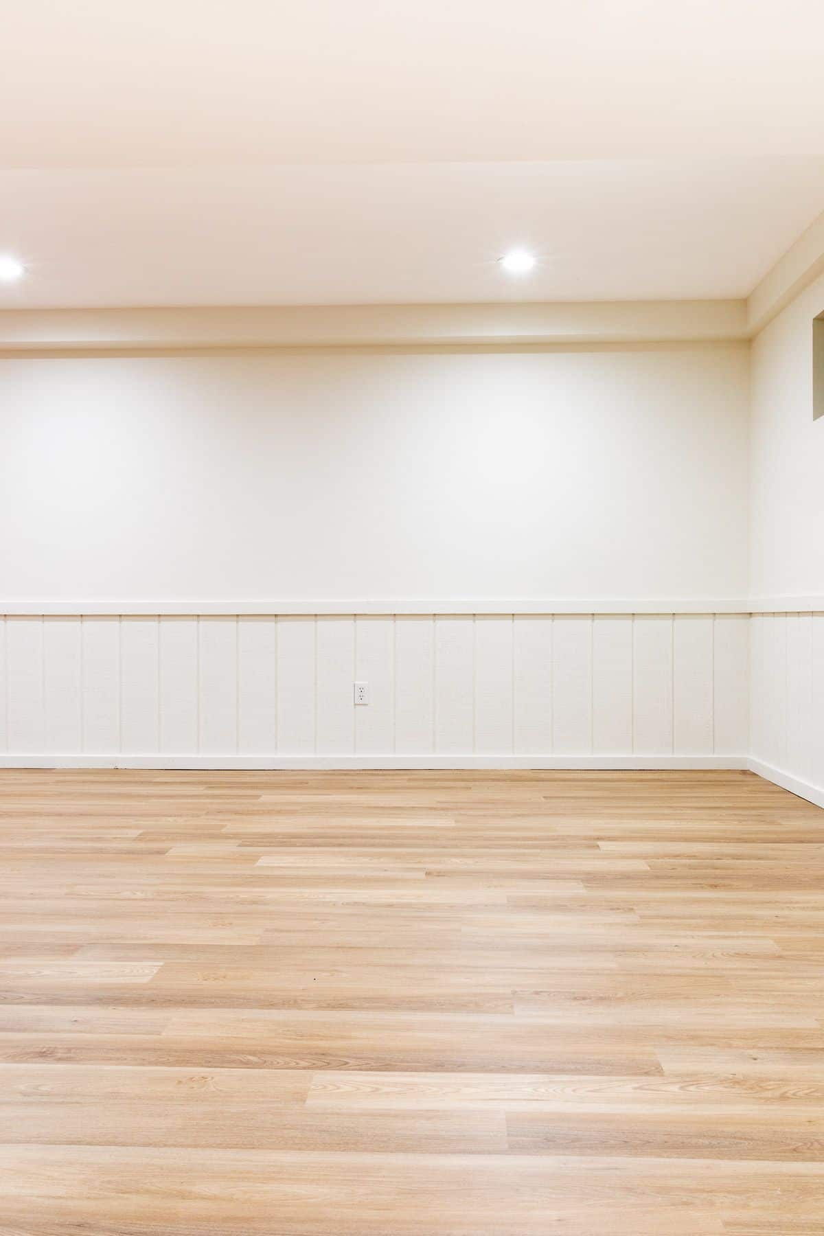 A freshly painted basement with LRV floors and Benjamin Moore Swiss Coffee paint color on the walls