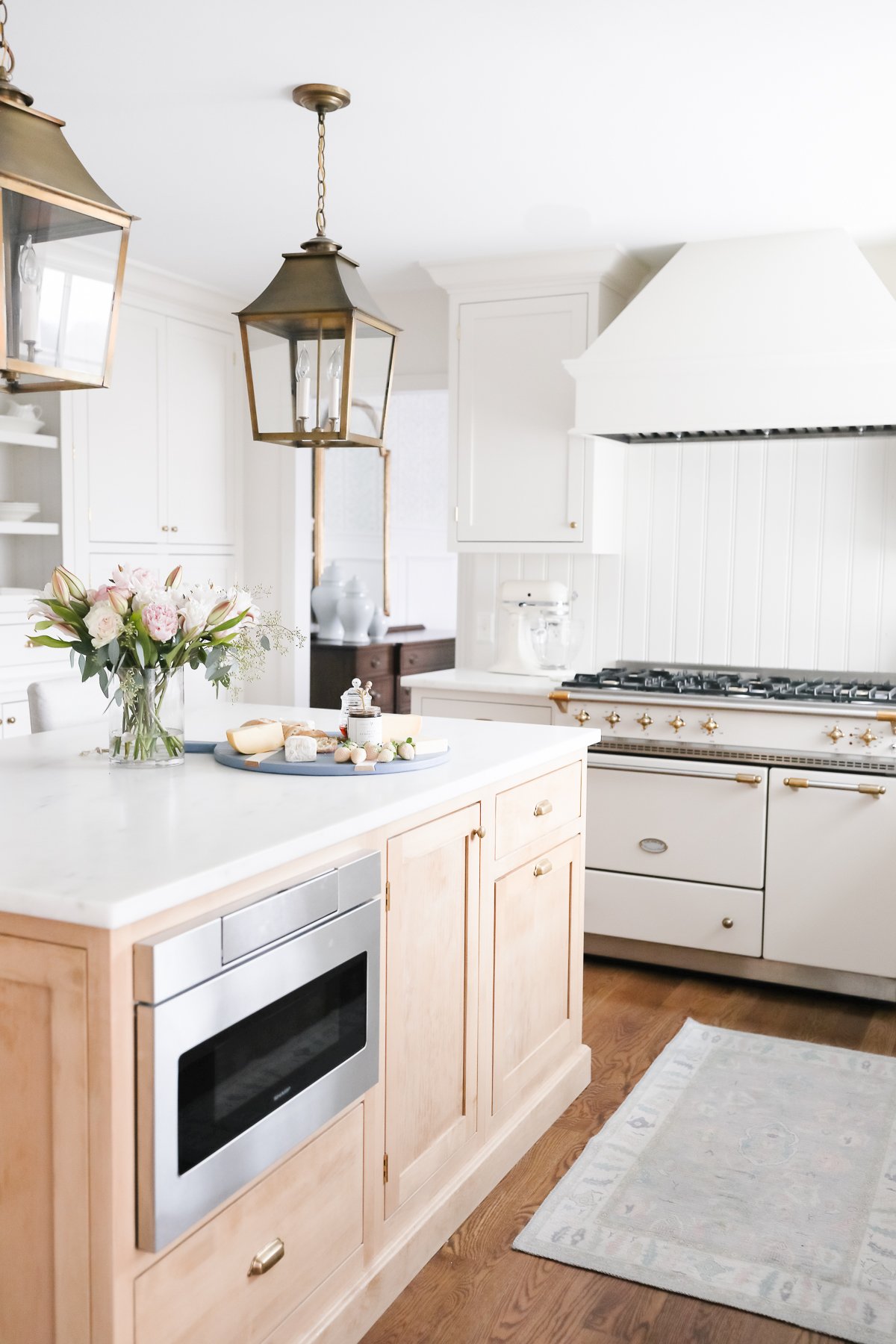 A white kitchen with custom cabinetry and a white island.