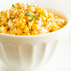 A white bowl of esquites (Mexican street corn salad).