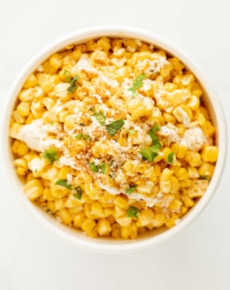 A white bowl of esquites (Mexican street corn salad).