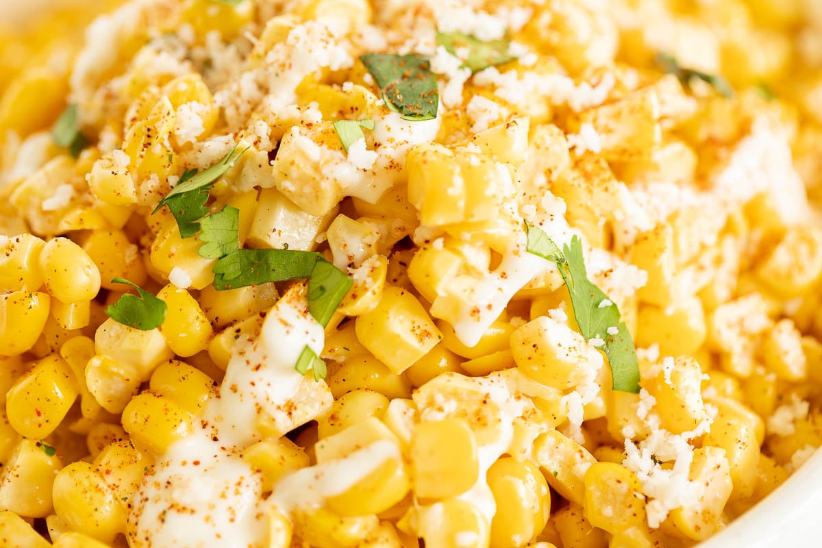 A white bowl of esquites (Mexican street corn salad).