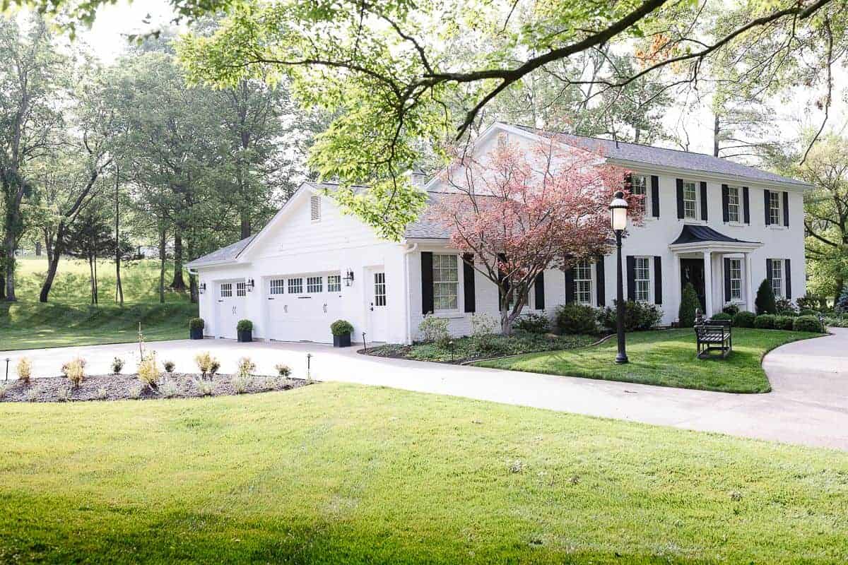 A colonial brick house painted in Benjamin Moore Simply White.