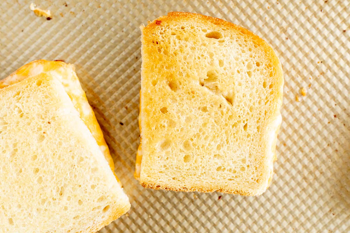 Oven grilled cheese on a gold baking sheet.