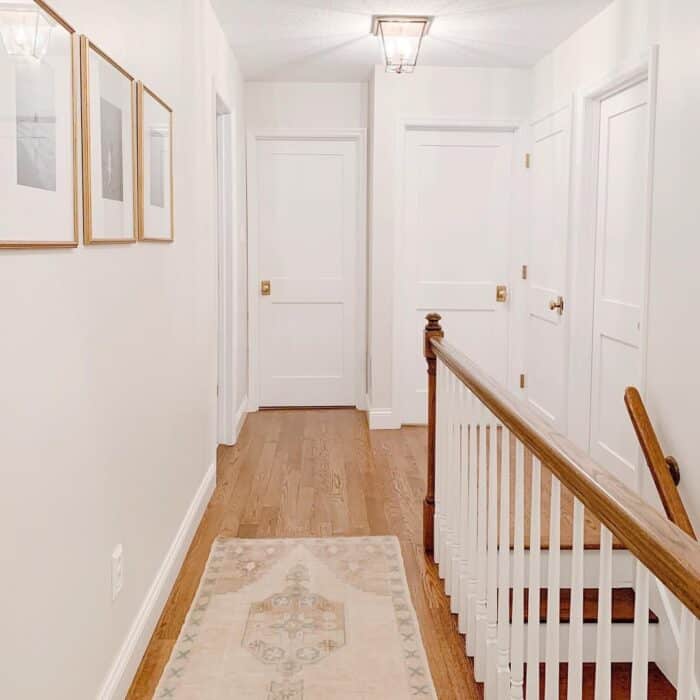 Soft white vs daylight in the overhead lanterns of a white home hallway.