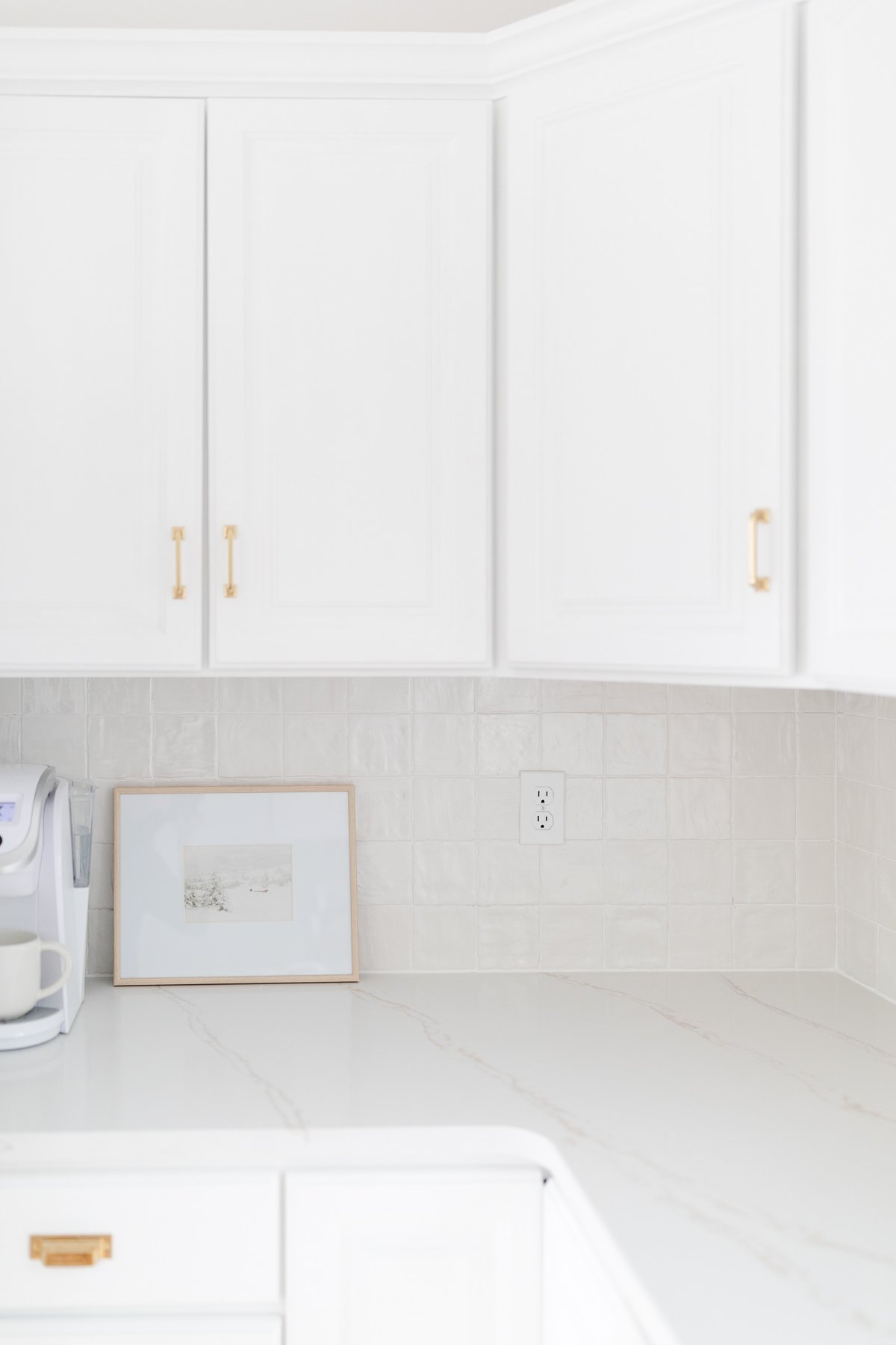 A white kitchen featuring white quartz countertops.