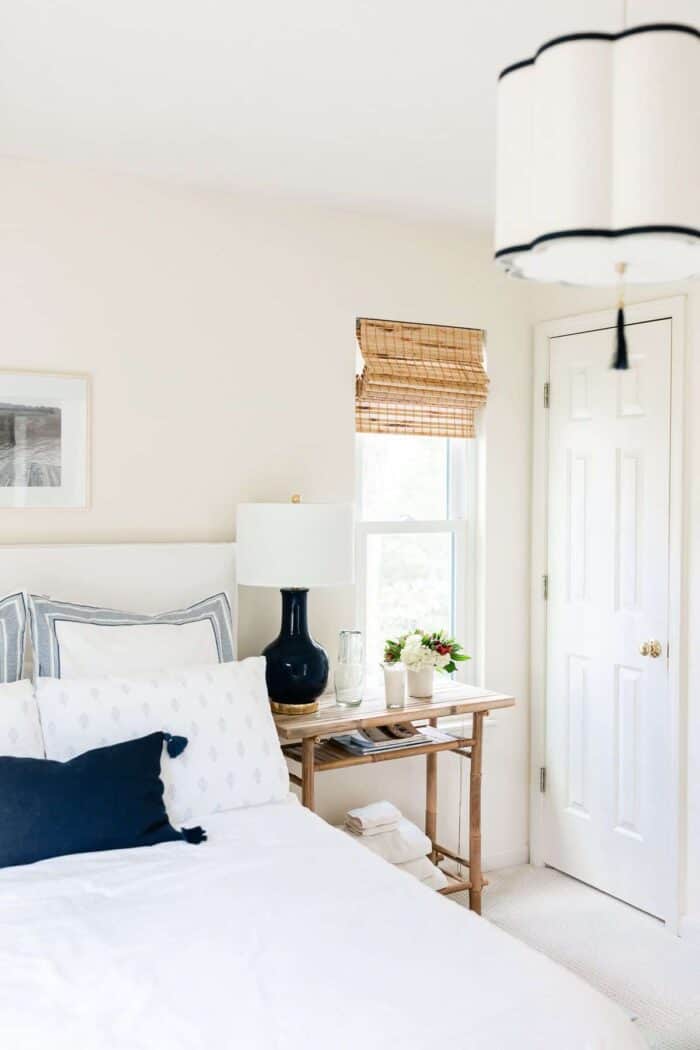 A small bedroom with a navy and white lamp and overhead pendant