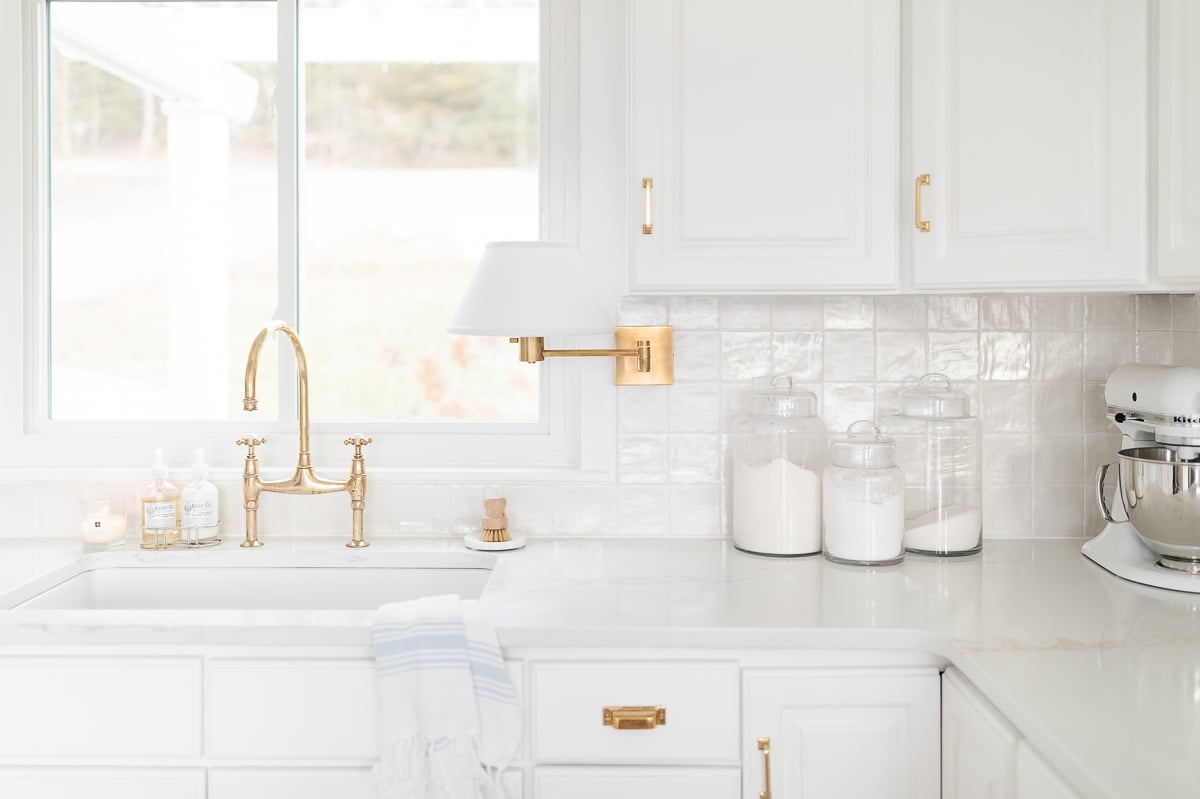 A white kitchen featuring white quartz countertops. 