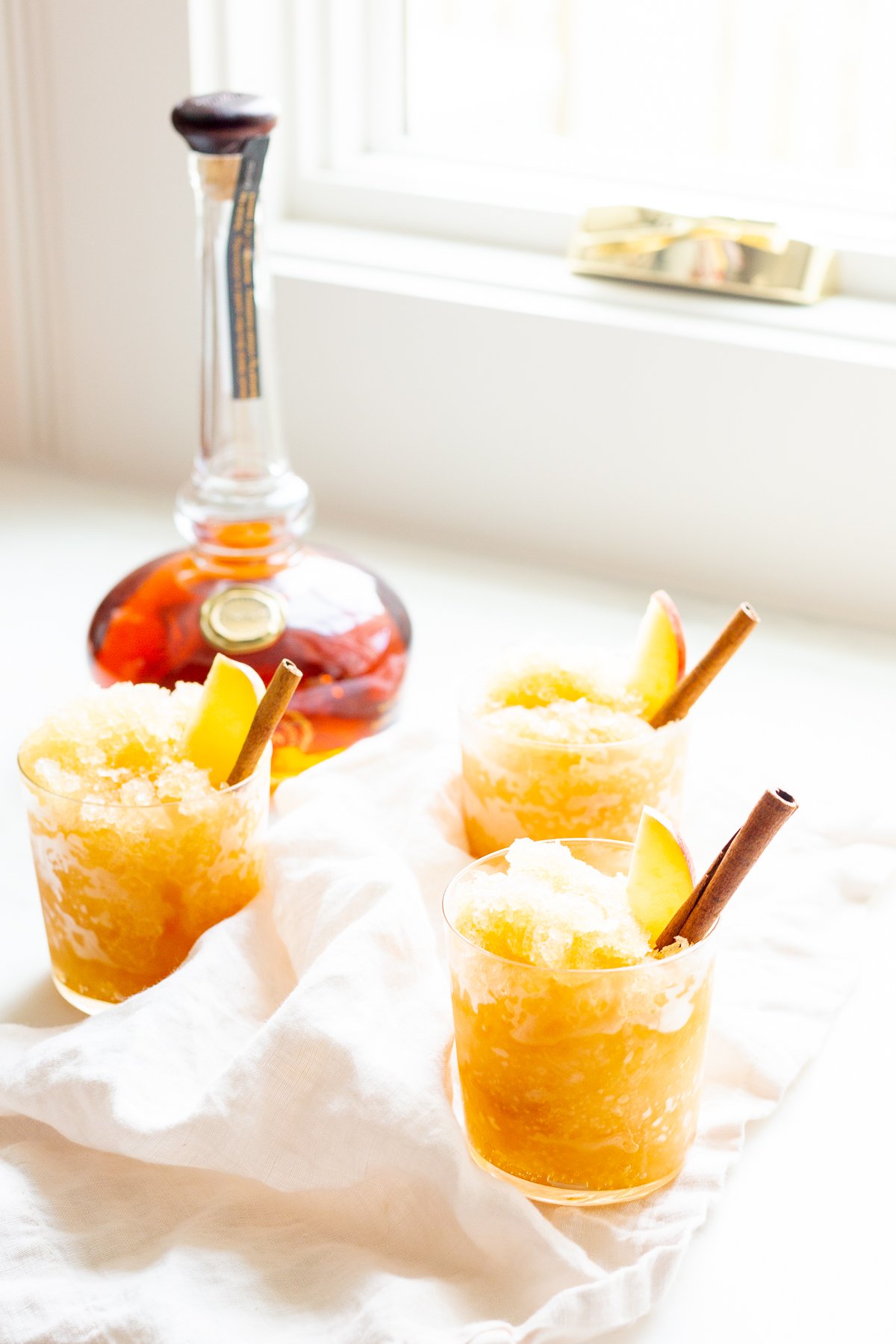 Apple cider slush with bourbon, garnished with a cinnamon stick