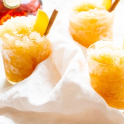 Apple cider slushies with bourbon, garnished with a cinnamon stick