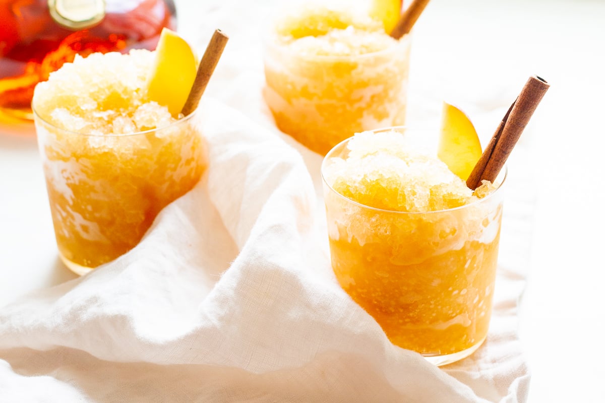 Apple cider slush with bourbon, garnished with a cinnamon stick