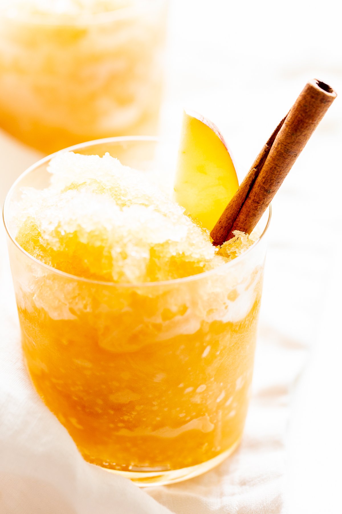 Apple cider slush with bourbon, garnished with a cinnamon stick