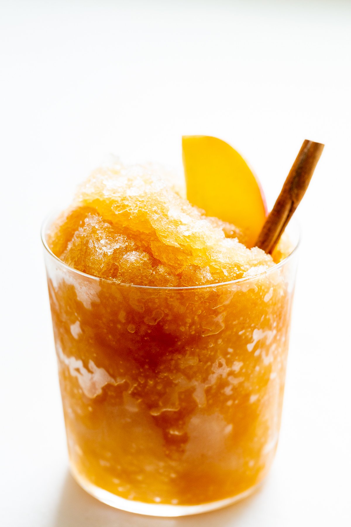 Apple cider slush with bourbon, garnished with a cinnamon stick