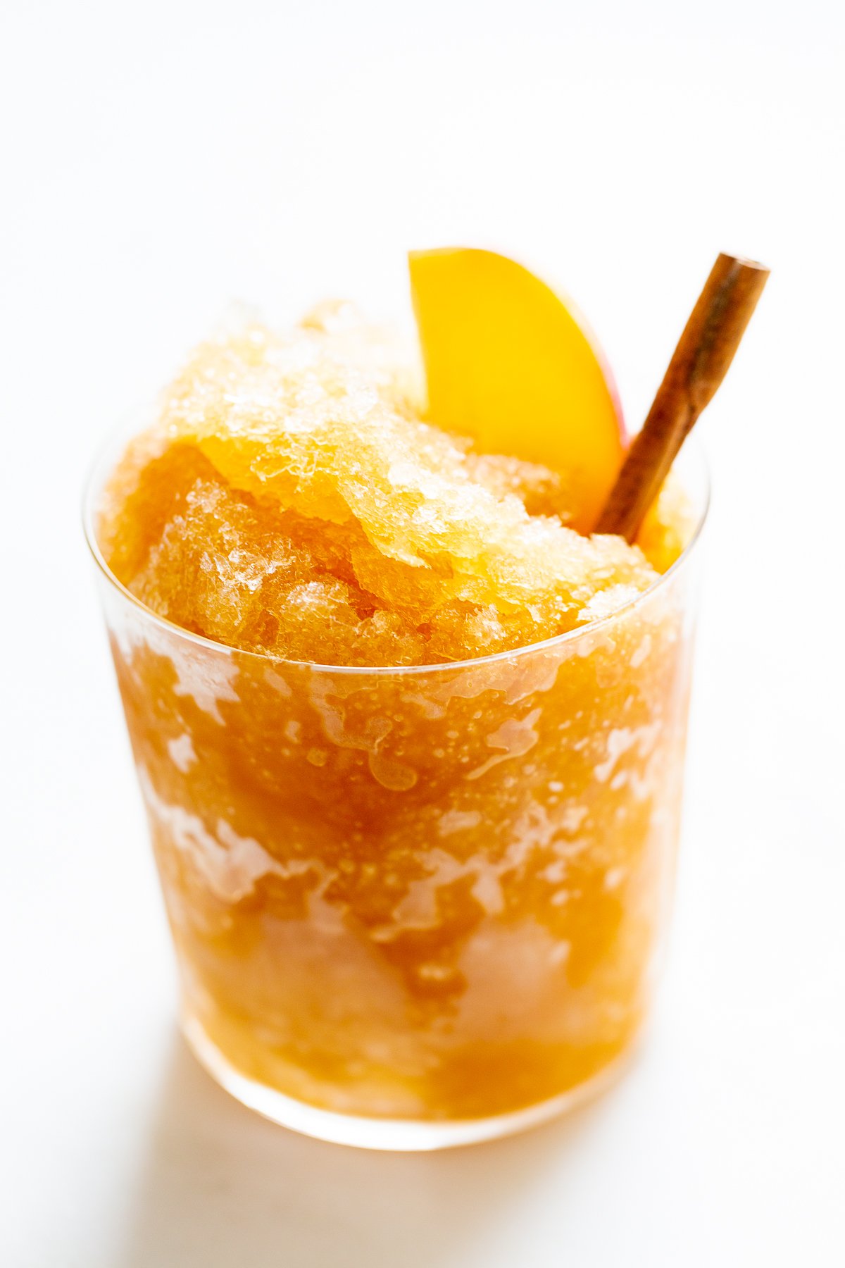 Apple cider slush with bourbon, garnished with a cinnamon stick