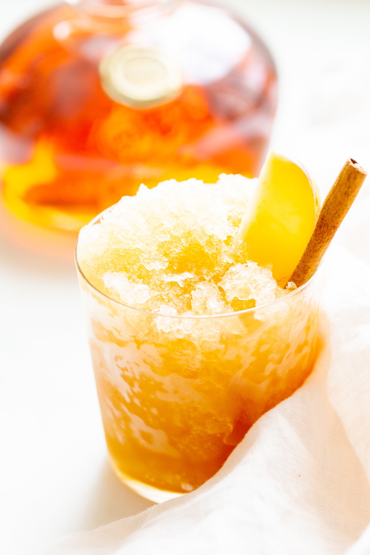 Apple cider slush with bourbon, garnished with a cinnamon stick