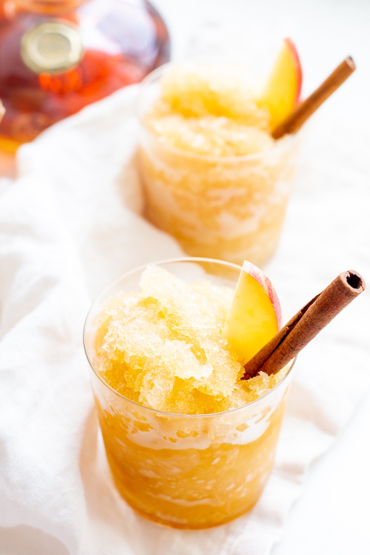 Apple cider slushies with bourbon, garnished with a cinnamon stick 