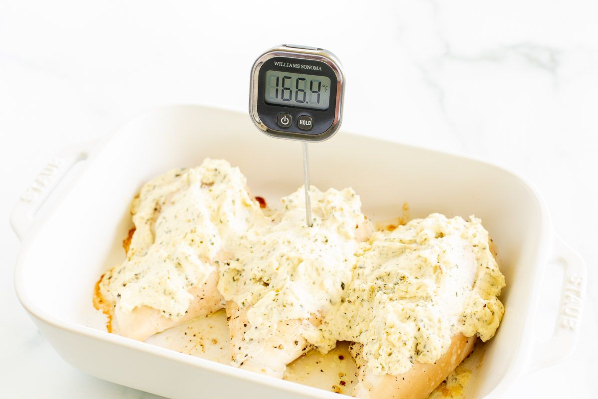 Boursin chicken breasts in a white baking dish with a digital thermometer.