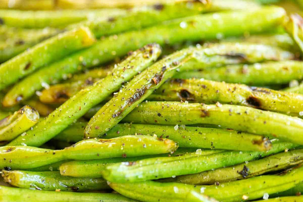 A close up shot of grilled green beans with some charring from the grill.