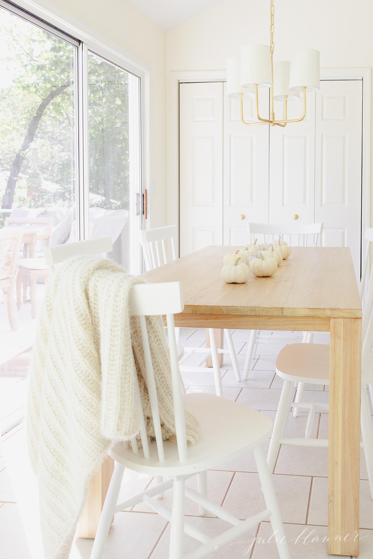 A minimalist dining room with a white table and chairs.