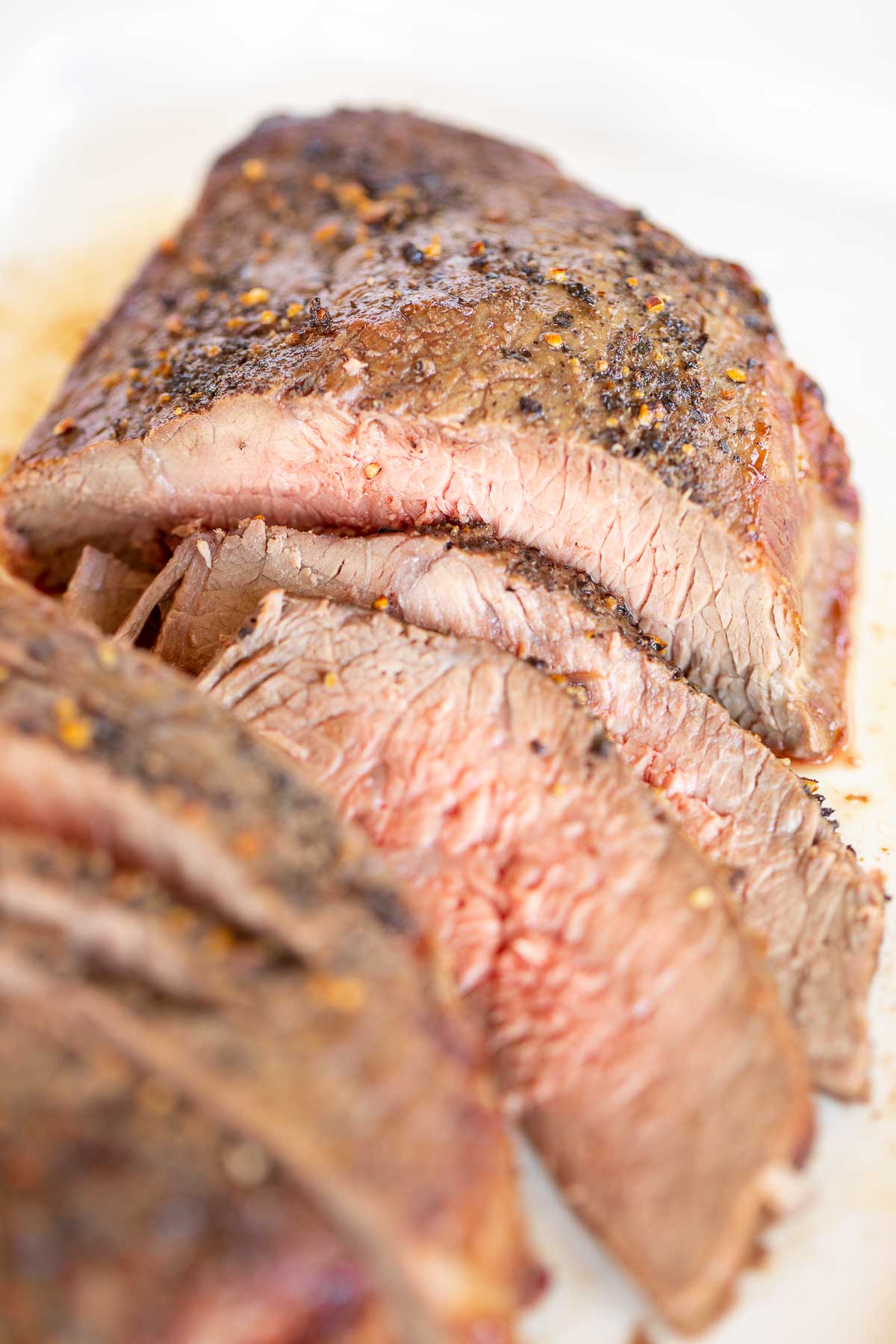 A perfectly cooked steak on a white plate, displaying the ideal temperature.