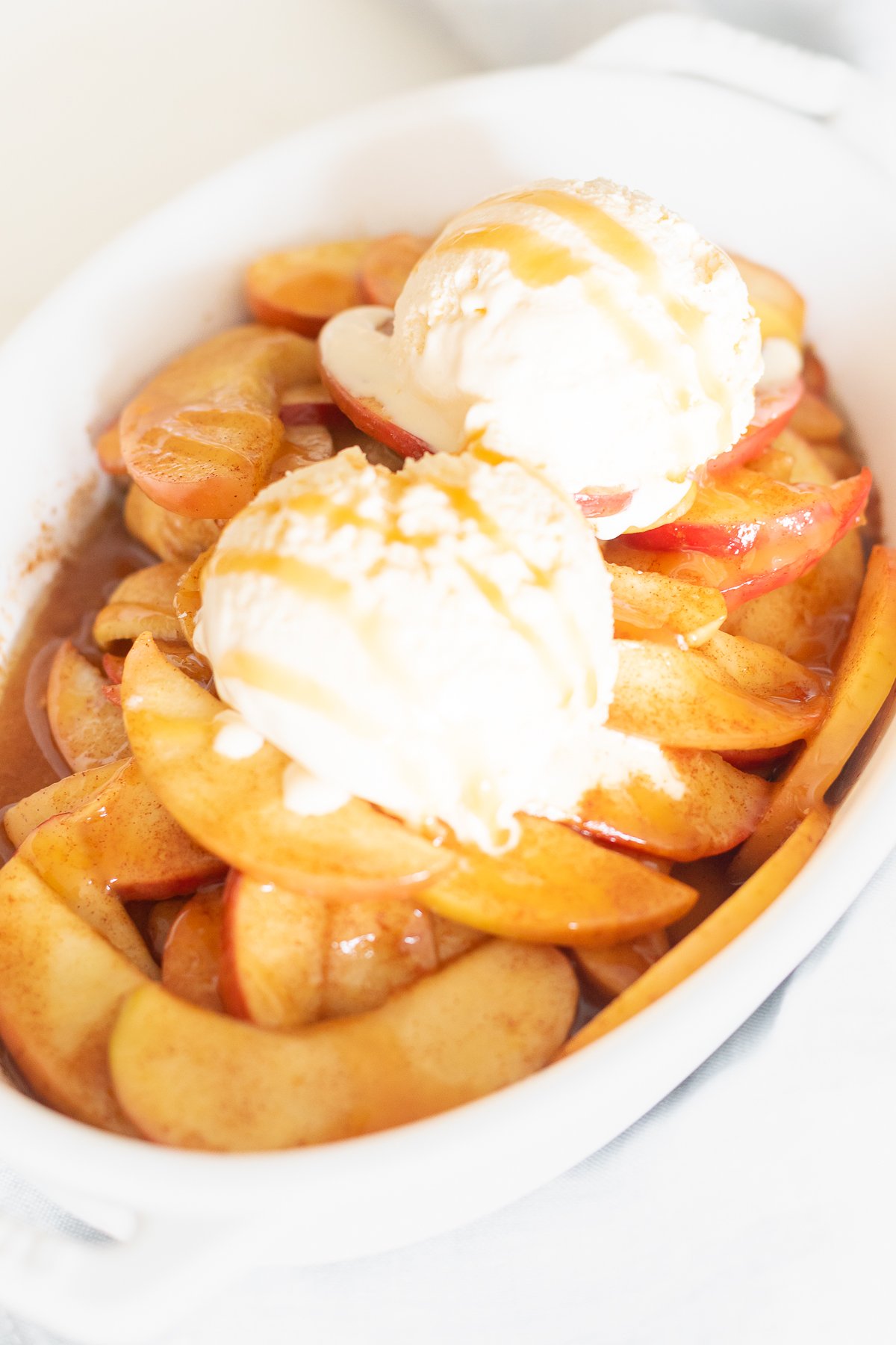 Baked apple slices served on a white dish.