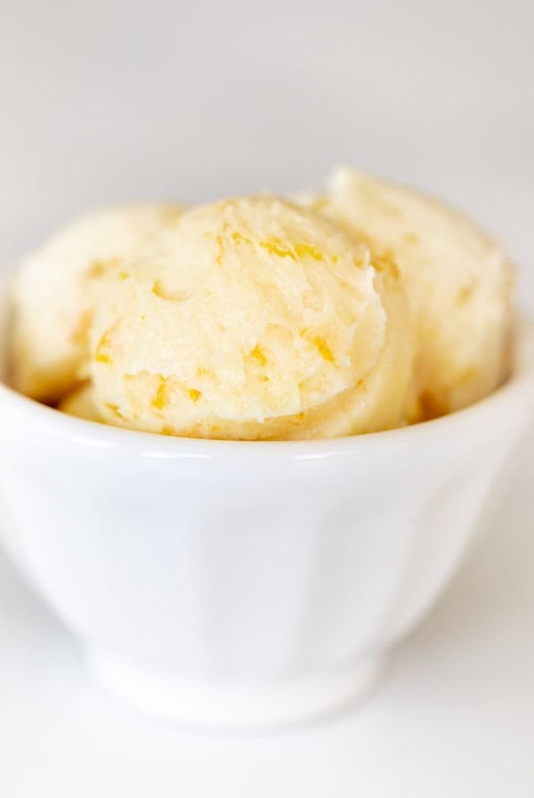 A white bowl filled with scoops of homemade orange butter.